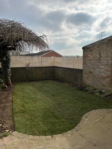 Elegant custom slatted fence installed on a wall for enhanced privacy in a residential garden