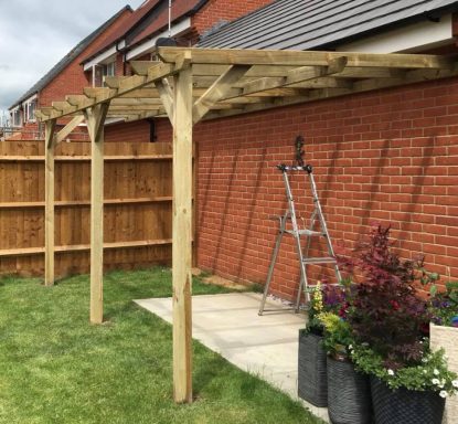 Classic pergola attached to a house, extending the outdoor living space in the garden