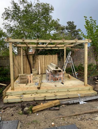 Stylish wooden pergola situated over a decking base, providing shade and aesthetic appeal